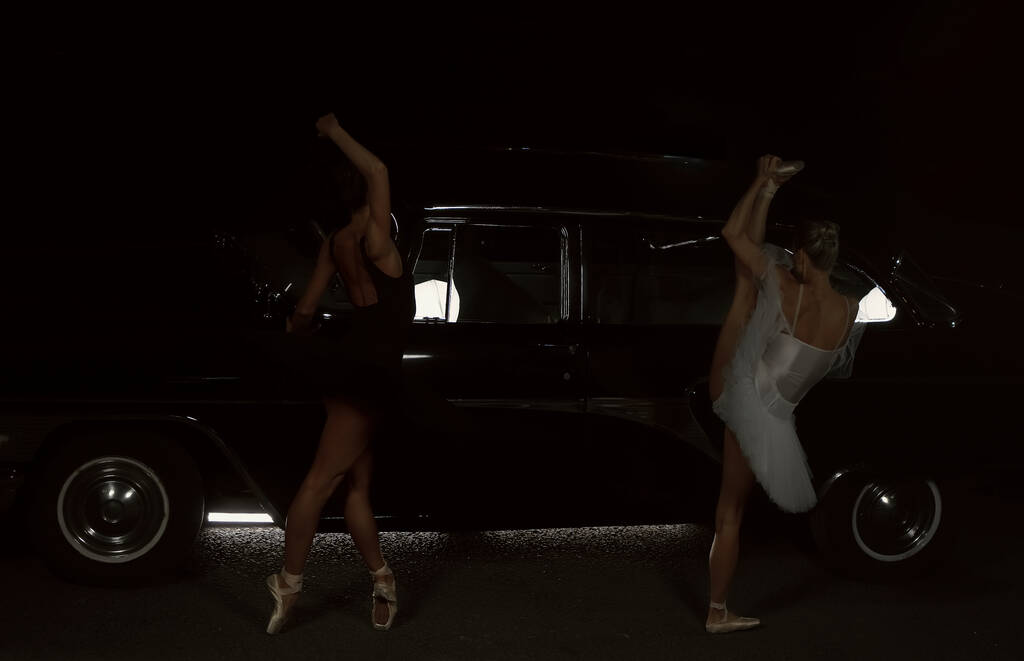 Portrét dvou baletních tanečnic tančících v noci poblíž retro auta.  - Fotografie, Obrázek
