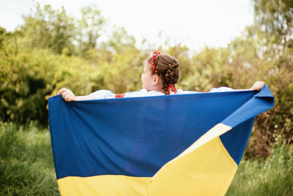 Día de la Bandera de la Independencia de Ucrania. Día de la Constitución. Niña ucraniana en camisa bordada vyshyvanka con bandera amarilla y azul de Ucrania en el campo. símbolos de la bandera de Ucrania. Kiev, día de Kiev - Foto, Imagen