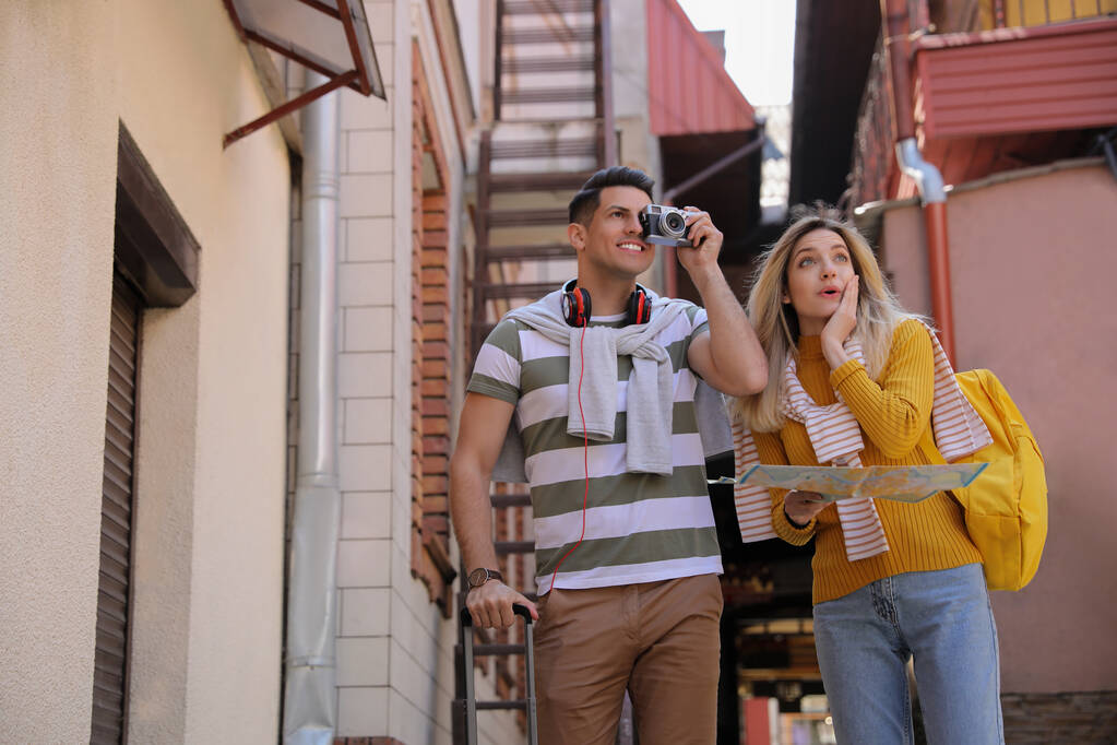 Пара туристов фотографируют на красивой городской улице - Фото, изображение