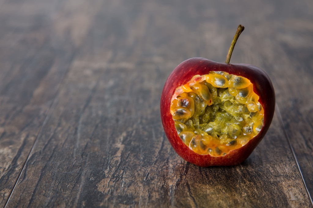 κόκκινο μήλο με δάγκωμα Ανοίξτε φρούτο του πάθους μέσα σε ξύλινη επιφάνεια - Φωτογραφία, εικόνα