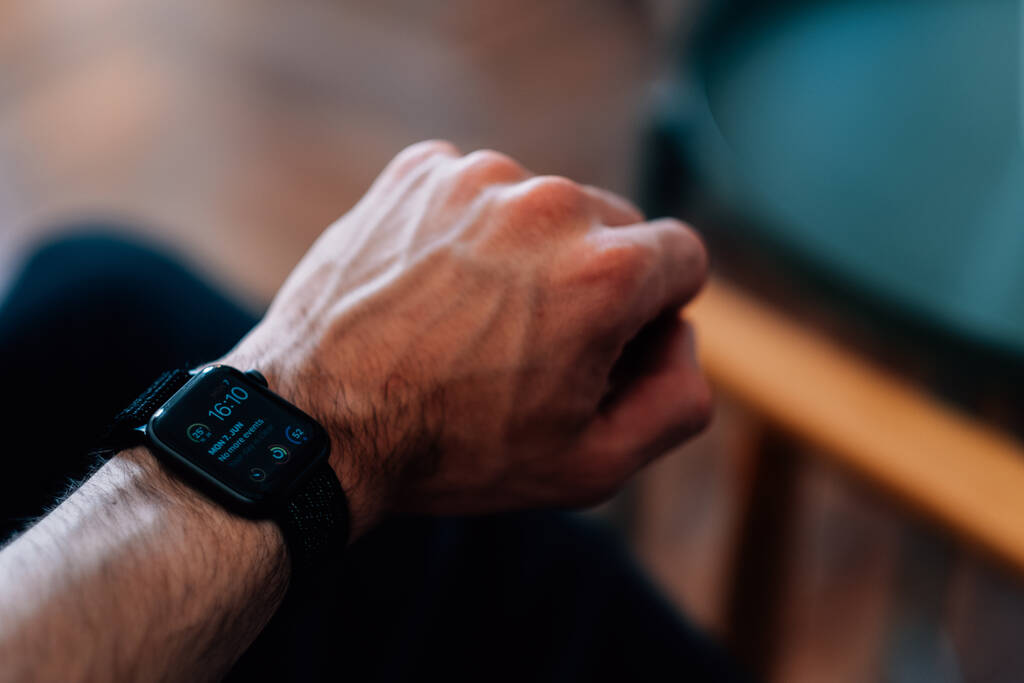 Eine selektive Fokusaufnahme der Hand eines Mannes, der eine schwarze Smart Watch trägt - Foto, Bild