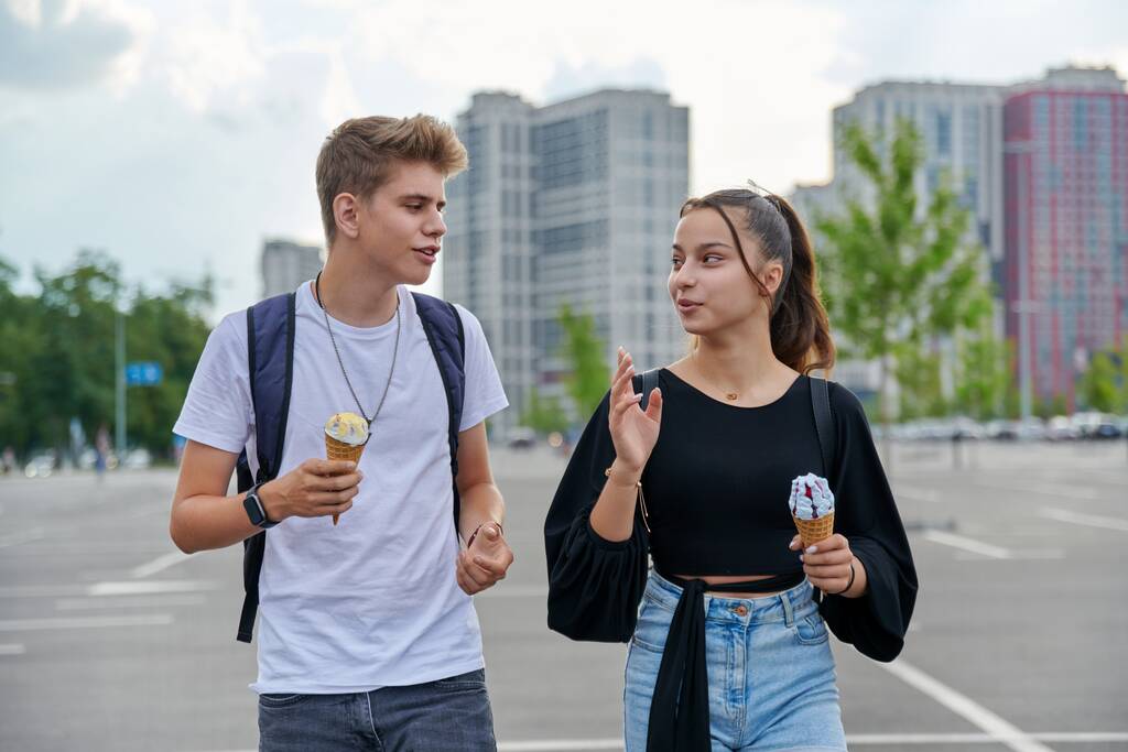 Gelukkig pratende tieners lopen samen in de stad - Foto, afbeelding