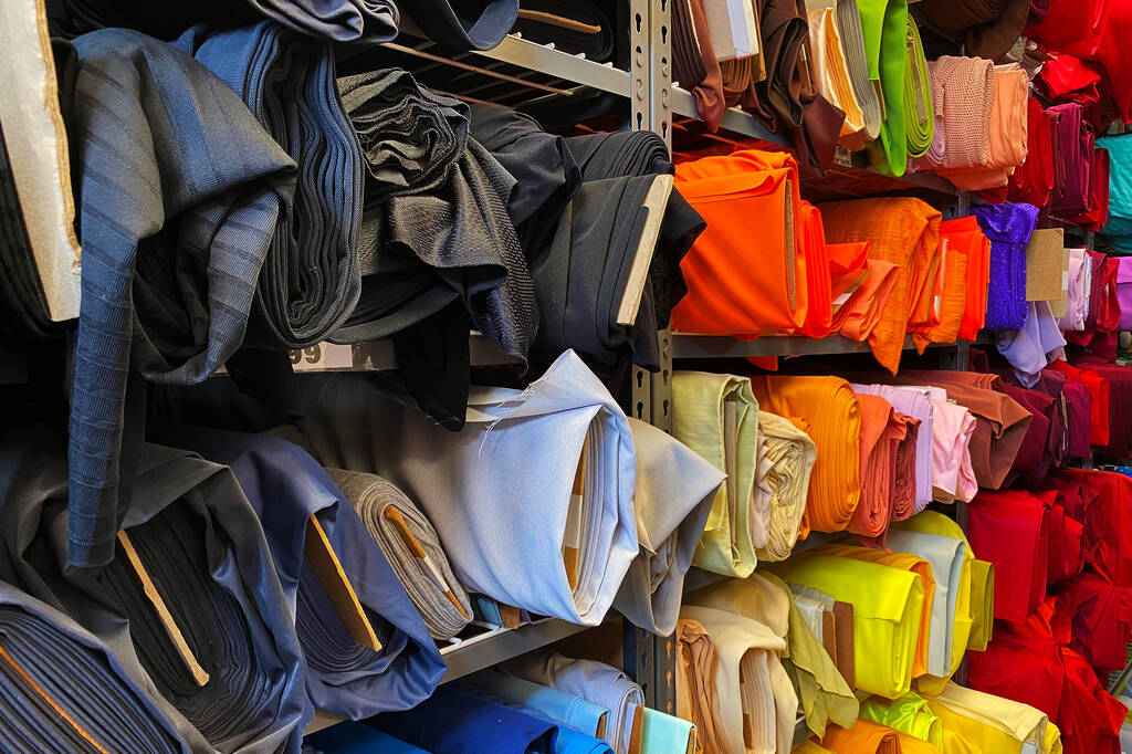 Una visione ravvicinata di diversi rotoli di colore di materiali venduti in un negozio di tessuti - Foto, immagini