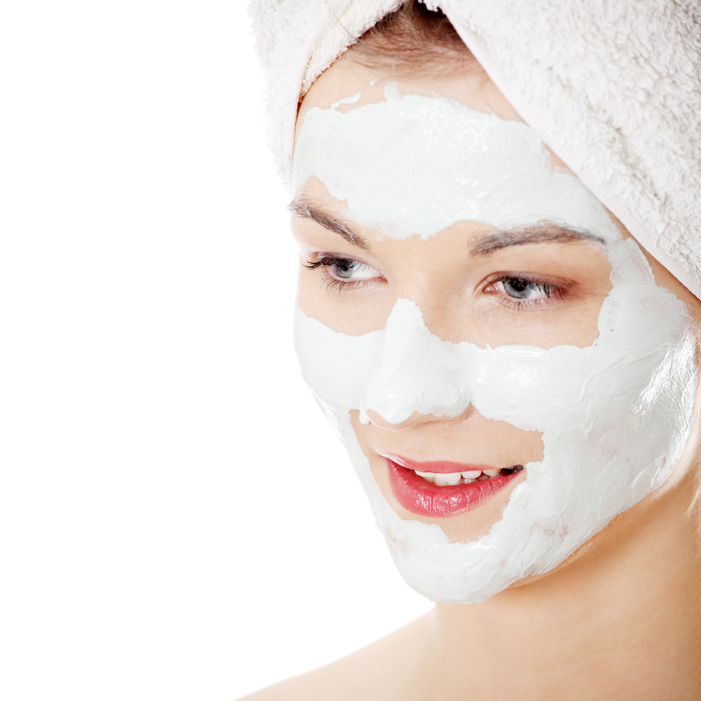 Máscara cosmética de arcilla en el hermoso rostro femenino joven, aislado en blanco
 - Foto, Imagen
