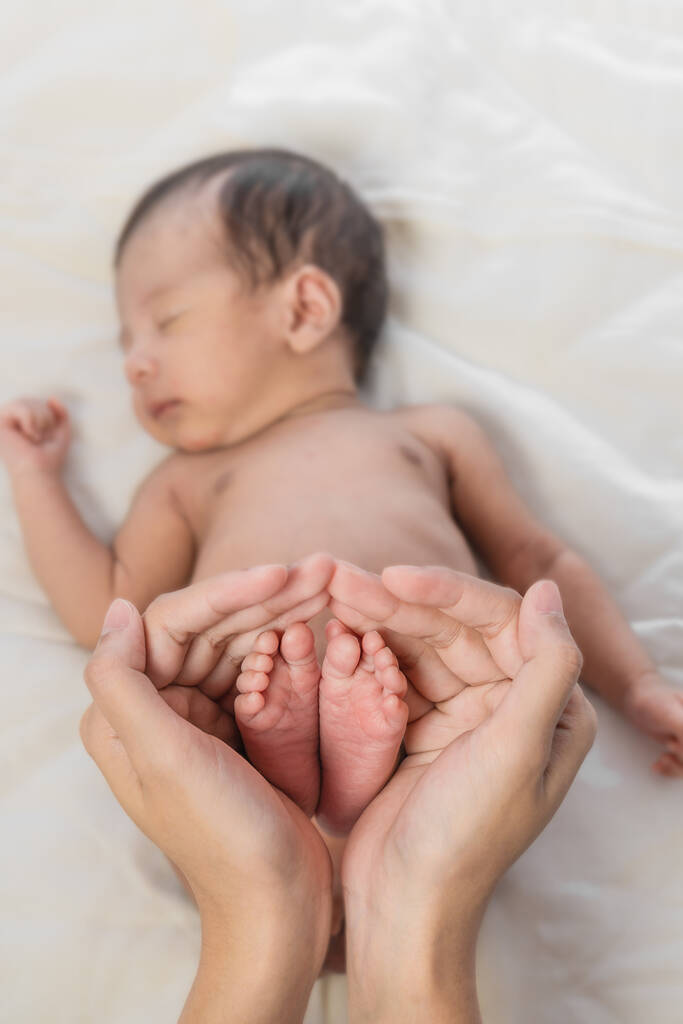 close up των ποδιών των νεογέννητων βρεφών εκμετάλλευση στο χέρι της μητέρας στην έννοια της αγάπης και της προστασίας από τους γονείς στο μωρό - Φωτογραφία, εικόνα