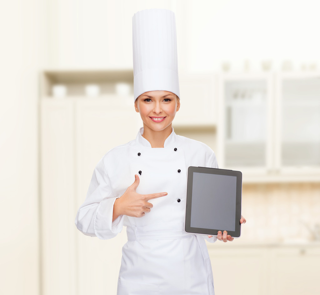 glimlachend vrouwelijke chef-kok met tablet pc-leeg scherm - Foto, afbeelding