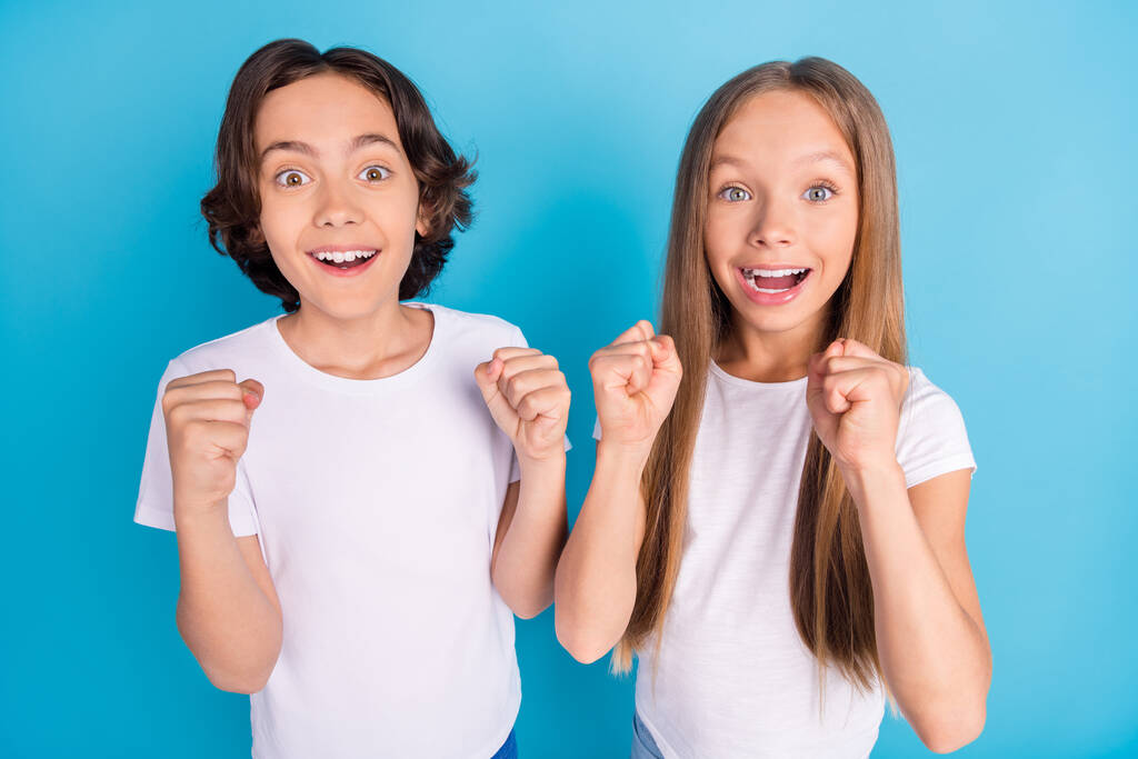 Foto de niños divertidos asombrados celebran marca logro desgaste camiseta blanca aislado color azul fondo - Foto, imagen