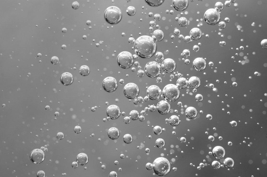 Повітряні бульбашки в рідині. Абстрактний чорно-білий фон. Має
 - Фото, зображення