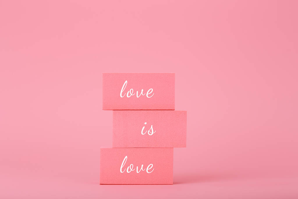 L'amore è amore concetto elegante in colori rosa brillante. L'amore è amore scritto su blocchi rettangolari rosa sullo sfondo rosa. Concetto di orgoglio Lgbtq posizione sociale, tolleranza, rispetto e pari diritti - Foto, immagini