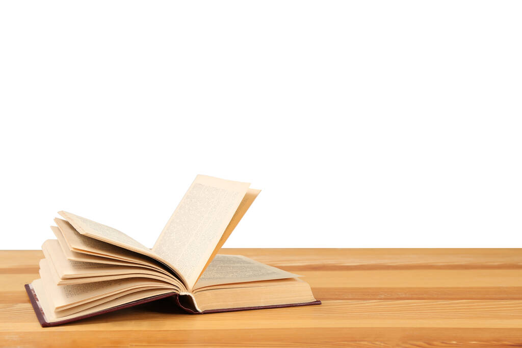 Открытая книга на деревянном столе на белом фоне. Библиотечный материал - Фото, изображение