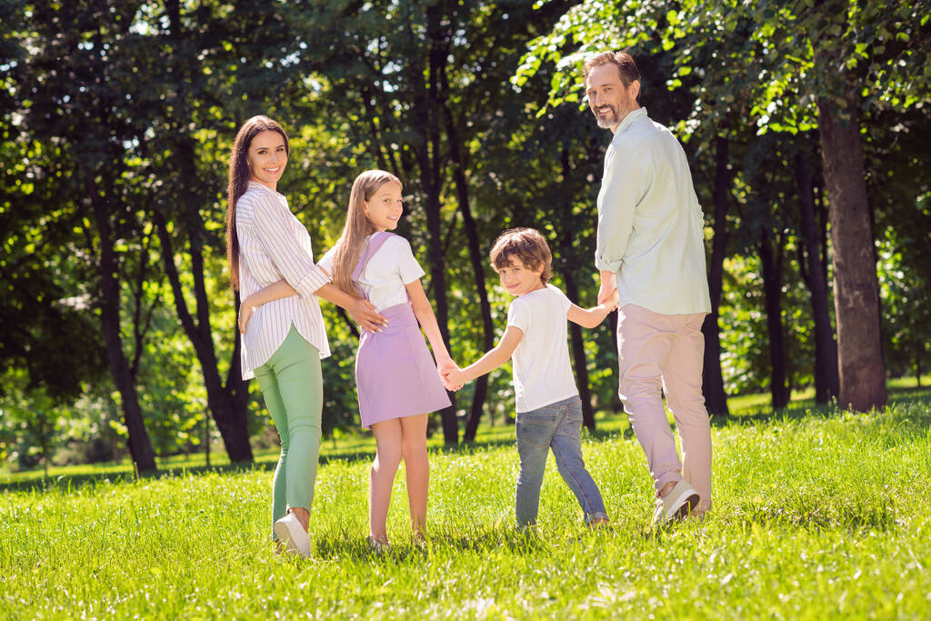 Plná délka těla pohled na atraktivní adoptivní pěstounské veselá rodina tráví čas na zelené trávě chůze čerstvý vzduch venku - Fotografie, Obrázek