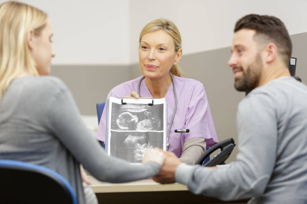 Schwangere und Ehemann mit Ultraschallbild in Absprache - Foto, Bild