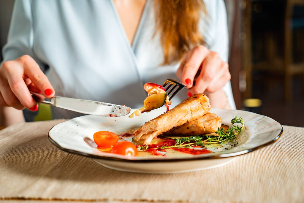 kobieta jedząc grillowanego kurczaka filet - Zdjęcie, obraz