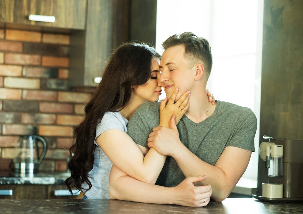 Életmód, család és fiatalok koncepció: szerető pár ölelkezve és csókolózva a konyhában - Fotó, kép
