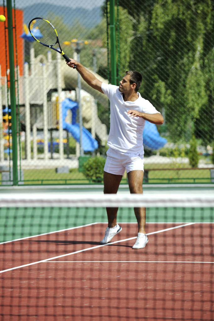 Молодий чоловік грає в теніс на відкритому повітрі
 - Фото, зображення
