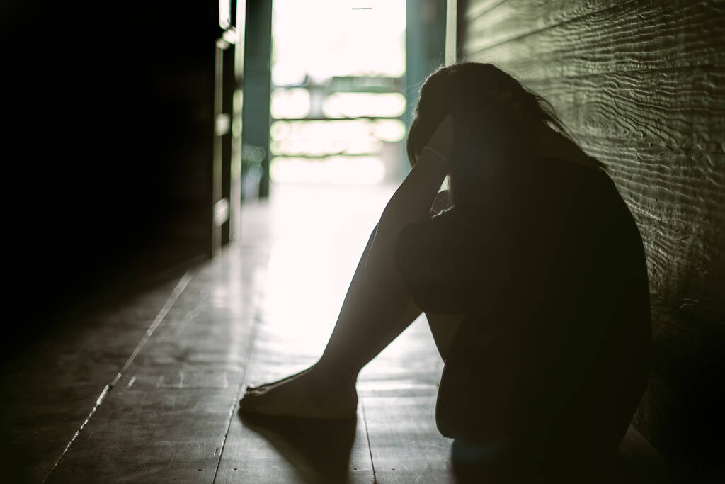 Λυπημένο μοναχικό κοριτσάκι που κλαίει ενώ κάθεται στο πάτωμα σε σκοτεινό δωμάτιο με μια στάση θλίψης.Έννοια της κατάθλιψης ή ενδοοικογενειακής βίας παιδί - Φωτογραφία, εικόνα