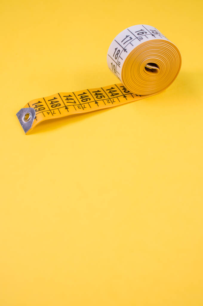 Eine Großaufnahme einer Meterrolle isoliert auf gelbem Hintergrund, mit freiem Raum - Foto, Bild