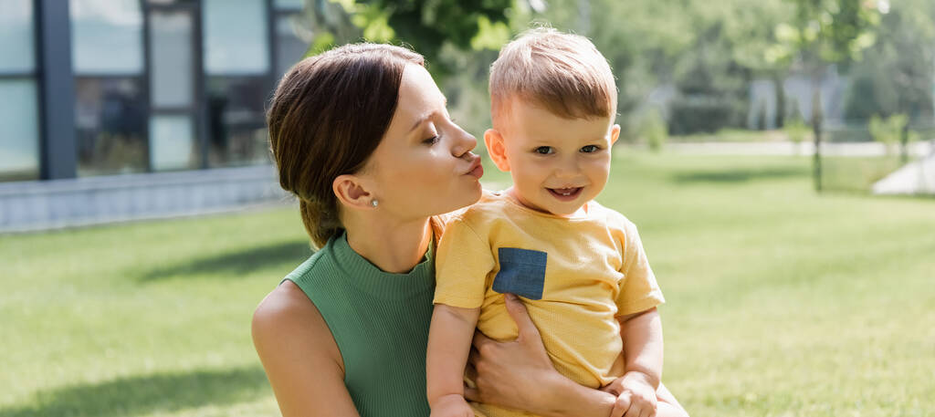 jeune mère embrasser heureux tout-petit fils à l'extérieur, bannière - Photo, image