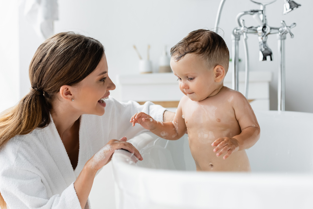 весела мати в купальнику мокрий малюк син у ванній
  - Фото, зображення