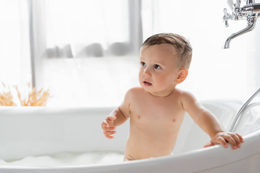 naked toddler boy taking bath in bathtub  - Photo, Image