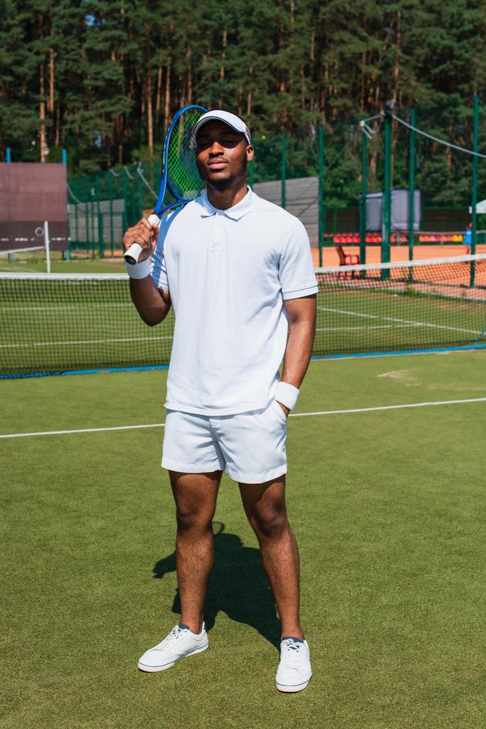 Afrikai amerikai teniszező kezében ütő a pályán  - Fotó, kép