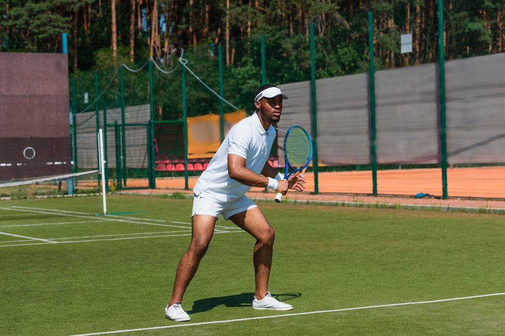 Сконцентрированный американский спортсмен, играющий в теннис на открытом воздухе  - Фото, изображение