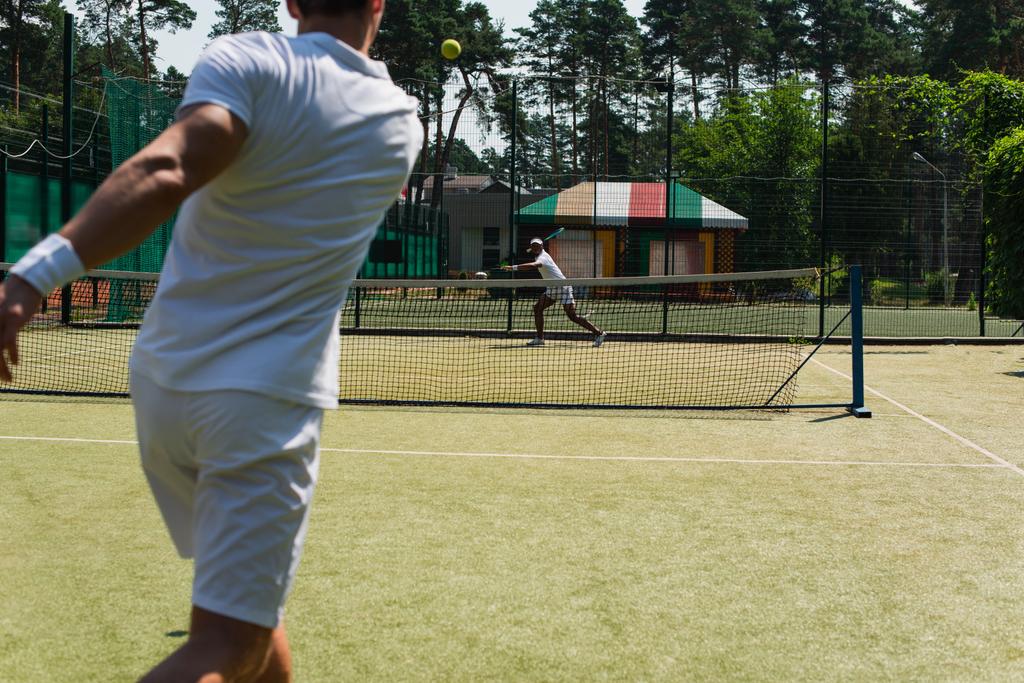 Açık havada bulanık arkadaşıyla tenis oynayan Afrikalı Amerikalı bir adam.  - Fotoğraf, Görsel