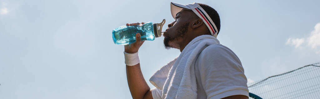 Matala kulma näkymä afrikkalainen amerikkalainen urheilija juomaveden ulkona, banneri  - Valokuva, kuva