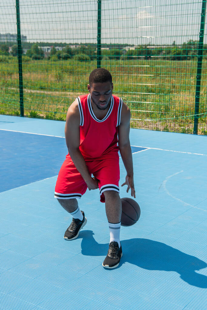 Jonge Afrikaanse amerikaanse speler met basketbal training op speelplaats  - Foto, afbeelding