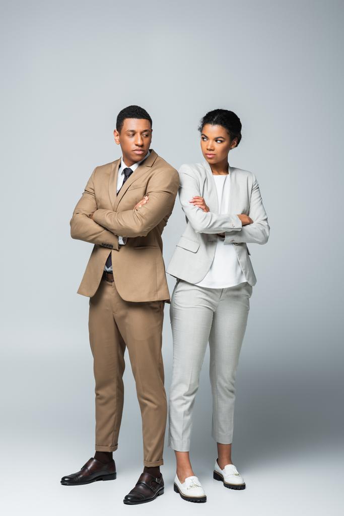 longitud completa de los empresarios afroamericanos de pie con los brazos cruzados en gris, concepto de igualdad de género - Foto, imagen