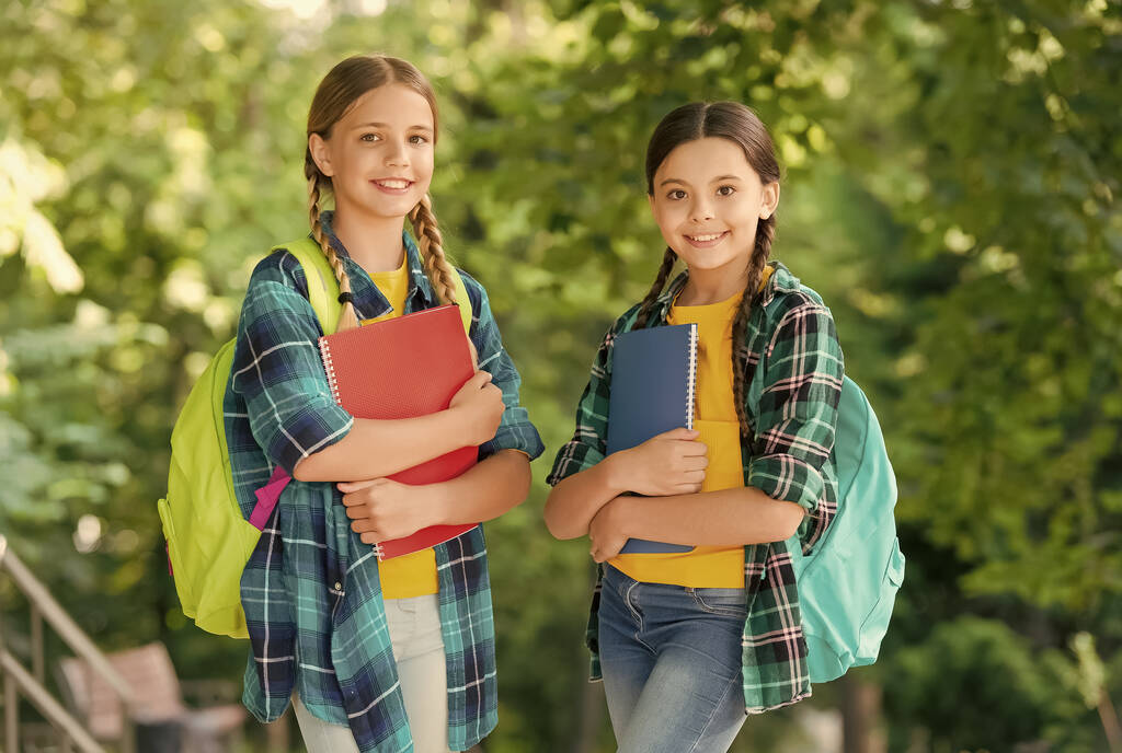 Bambini svegli in stile casual moda con smart look portare libri di studio e borse scolastiche paesaggio naturale, doposcuola - Foto, immagini