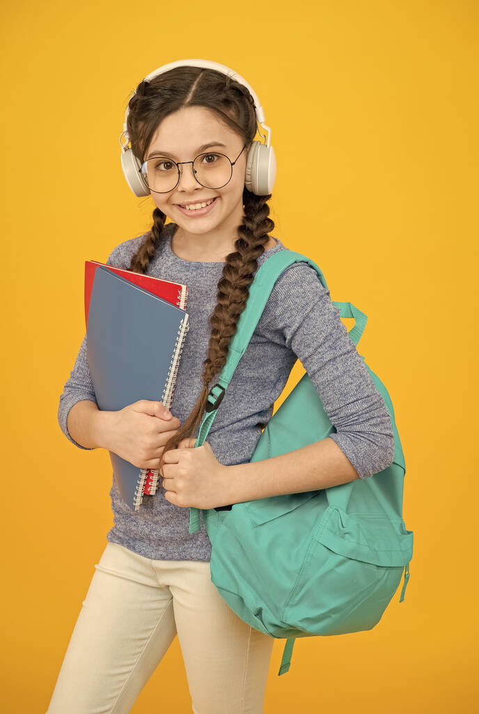 Hört die Lektion nicht auf. Kleines Mädchen trägt Kopfhörer. Glückliches Kind zurück in die Schule. Privatunterricht. Hörfähigkeiten. Musikstunde. Sprachschule. Englischkurse - Foto, Bild