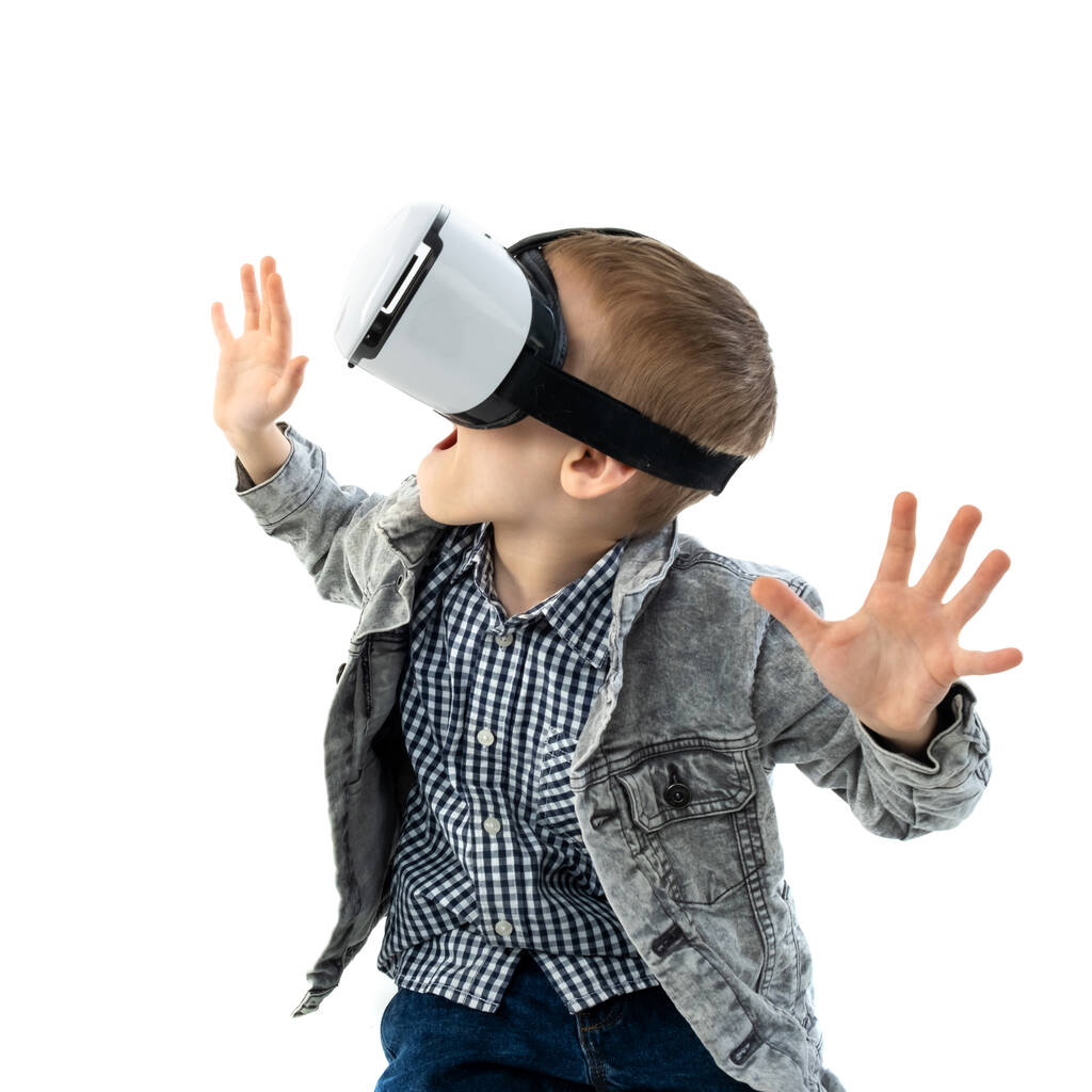 Молодий хлопчик з окулярами віртуальної реальності ізольований на білому тлі. Дитина в емоційному збудженні носить 3D окуляри
. - Фото, зображення