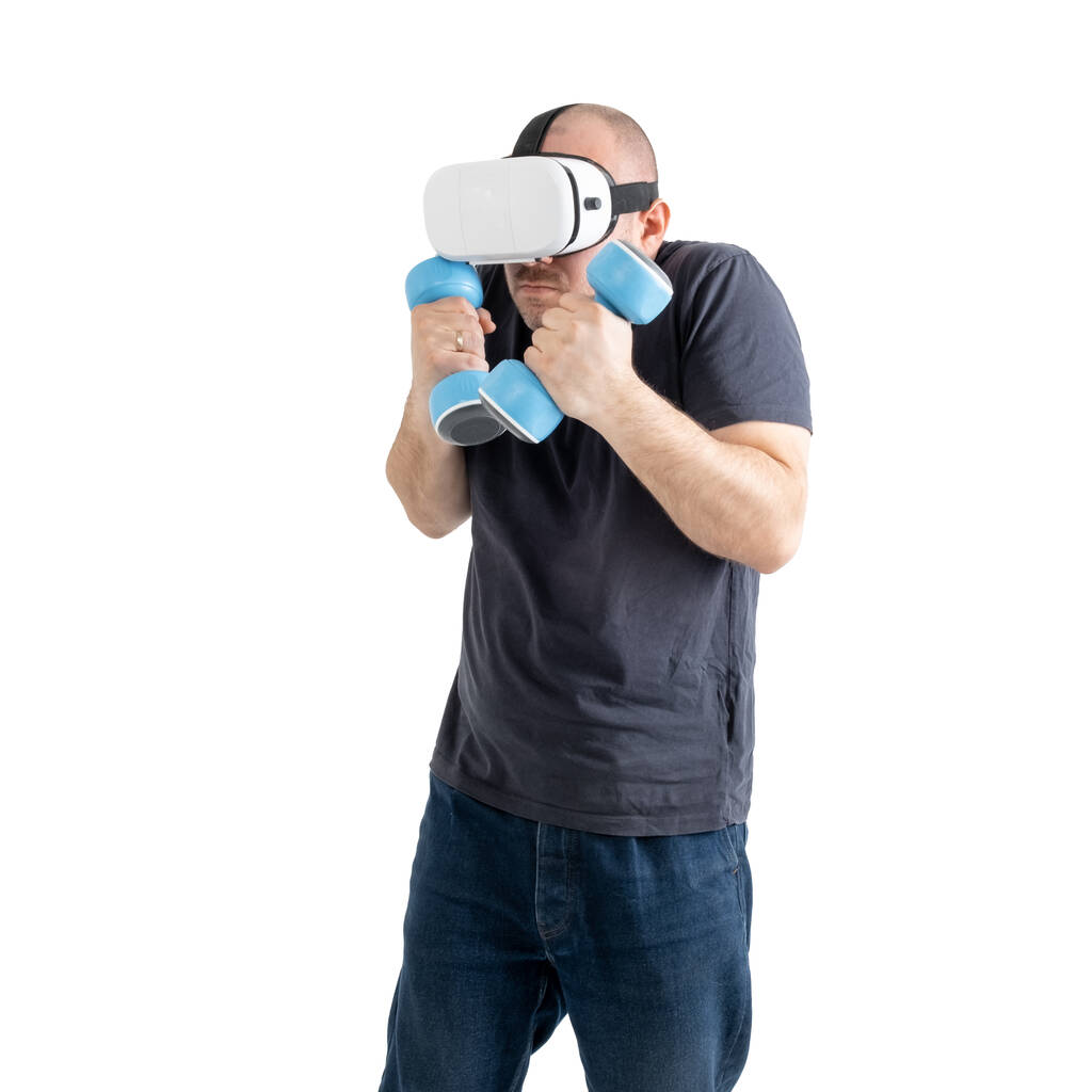 Неспортивный мужчина средних лет в очках виртуальной реальности с гантелями. Изолированный на белом фоне. - Фото, изображение