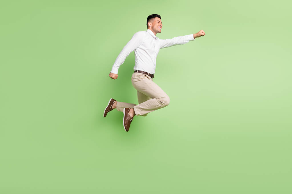 Pełna długość zdjęcie cute zabawny dżentelmen nosić białą koszulę uśmiechając skoki wysoki patrząc puste miejsce odizolowane zielony kolor tło - Zdjęcie, obraz