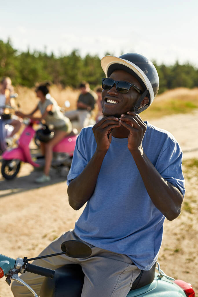 Portrét mladého afrického Američana, jak si nasazuje helmu - Fotografie, Obrázek