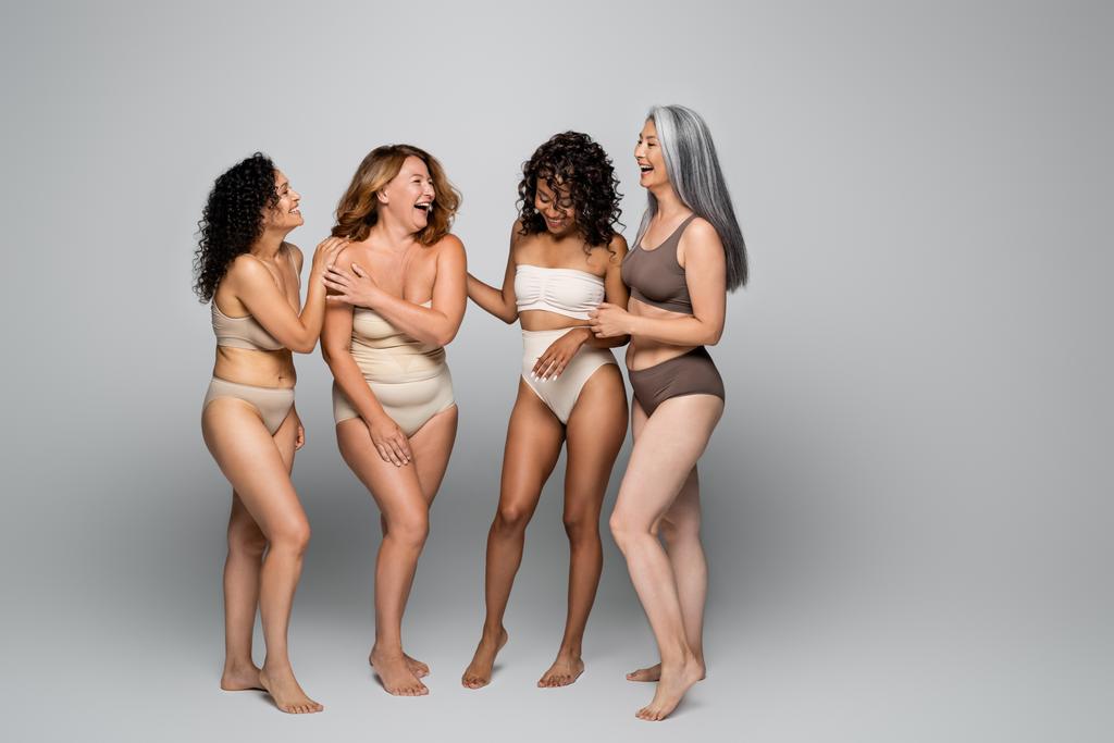 Happy multikulturní ženy ve spodním prádle na šedém pozadí  - Fotografie, Obrázek