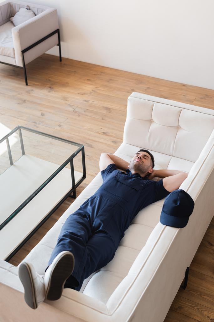 високий кут зору виснаженого майстра спить на білому дивані
 - Фото, зображення