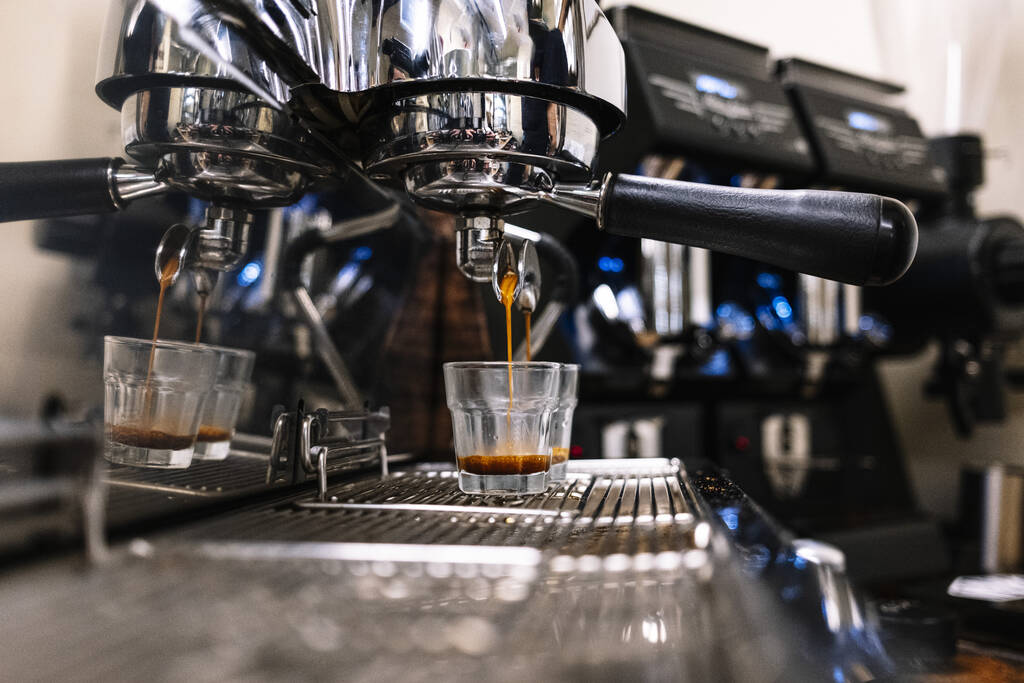 крупним планом процес виробництва еспресо з чашкою кави під портативним фільтром сучасної кавоварки
 - Фото, зображення