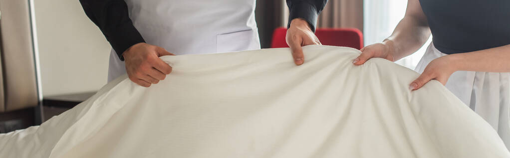 cropped view of housekeepers changing bedding in hotel room, banner - Photo, Image