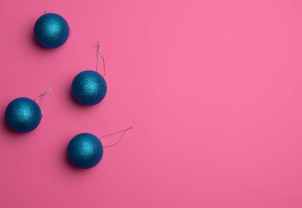 blue shiny Christmas balls on a pink background, festive backdrop for Christmas and New Year, copy space - Photo, Image