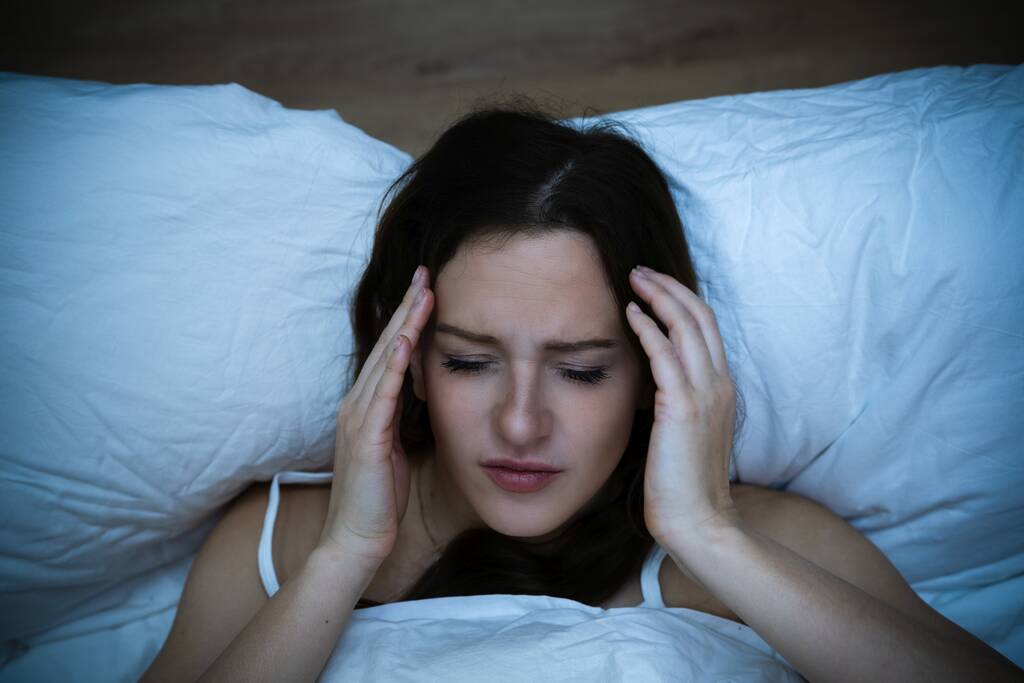 Stresszes nő fejfájással Ágyban alszik álmatlanságban - Fotó, kép
