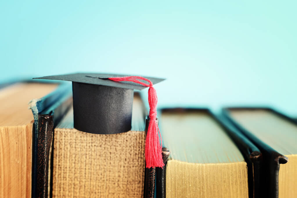 Image of education concept. Traditional graduation hat over books - Photo, Image