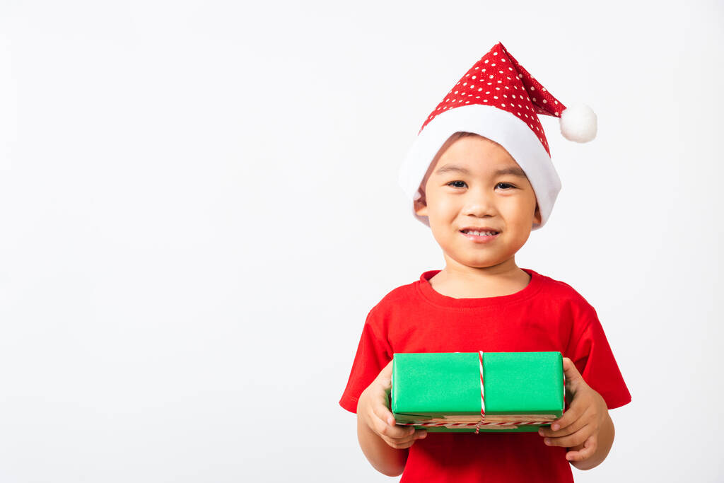 Niño asiático lindo niño sonrisa y emocionado, Niño vestido de rojo Santa Claus sombrero celebrar caja de regalo en las manos concepto de fiesta Navidad día de Navidad o feliz año nuevo aislado sobre fondo blanco - Foto, imagen