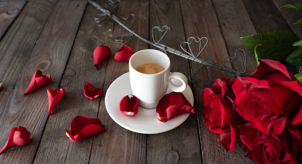 Kuppi kahvia punaisia ruusuja ja sydämiä tumma vintage lankkuja. Aamiainen tausta Ystävänpäivä konsepteja. - Valokuva, kuva