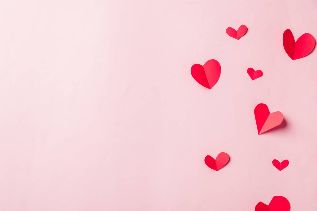Valentijnsdag achtergrond. Patroon mooie rode papieren harten gesneden samenstelling groet gift card geïsoleerd op roze achtergrond met kopieerruimte, Symbool van de liefde Top View from above. - Foto, afbeelding