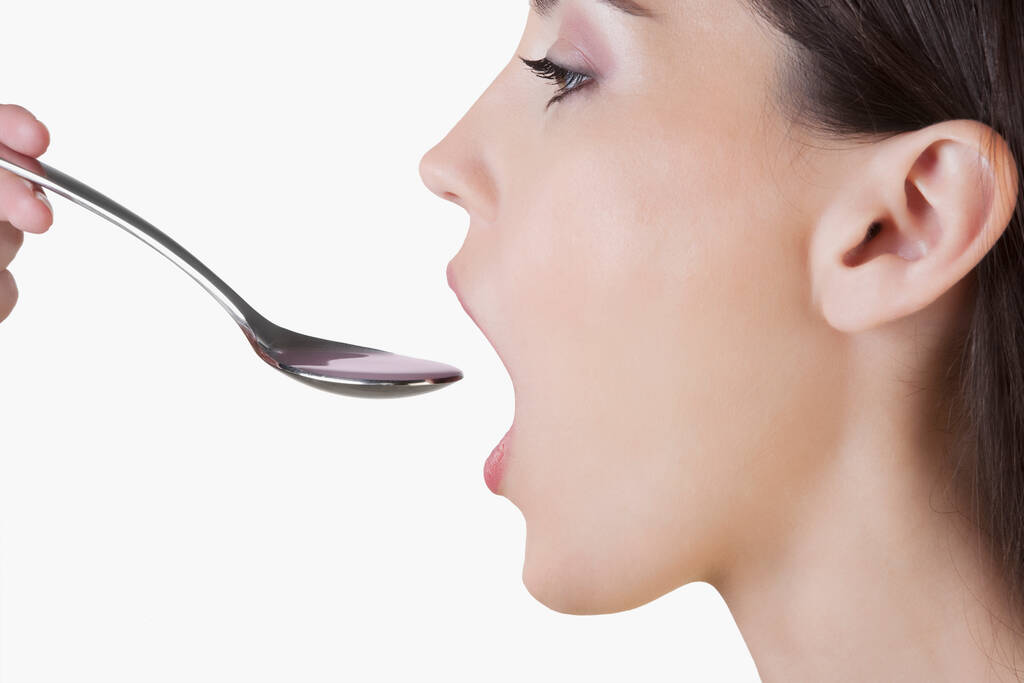 close-up of a woman eating a spoon - Photo, Image