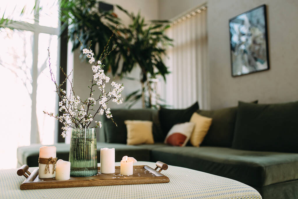 prachtig luxe interieur van moderne woonkamer met bloemen en kaarsen - Foto, afbeelding