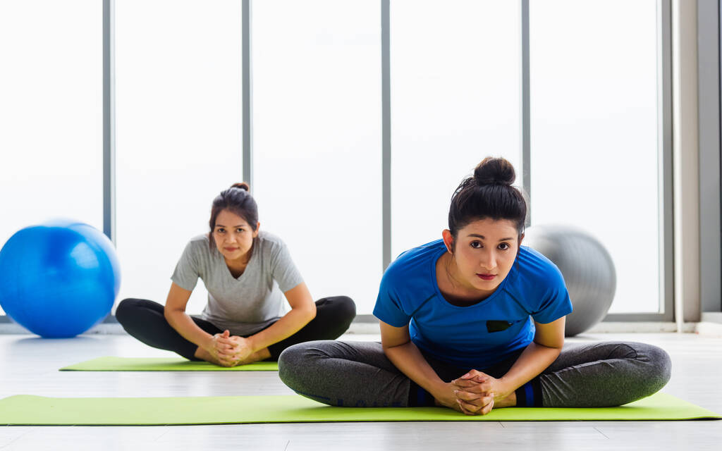 Duas mulheres asiáticas desportivas atraentes pessoas praticando aula de ioga juntos, trabalhando na aptidão GYM, Jovens e idosos do sexo feminino exercitando-se fazer ioga em aulas de ioga, esporte saudável estilo de vida - Foto, Imagem