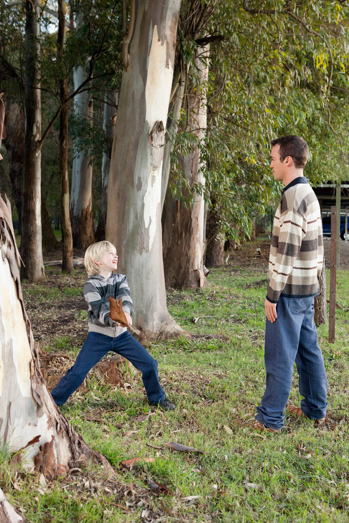 Vater und Sohn spielen mit dem kleinen Jungen im Wald - Foto, Bild